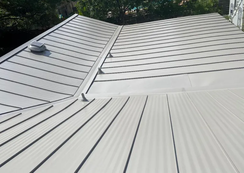 Solar attic fan installed on a metal roof for Roof Ventilation in Wright